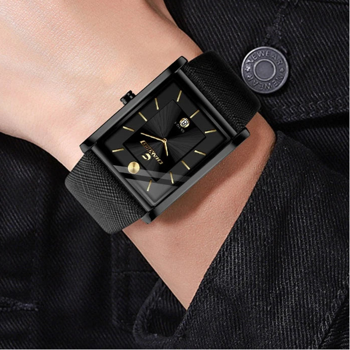 Close-up lifestyle shot of a man wearing a sleek all-black rectangular tank watch on his wrist.