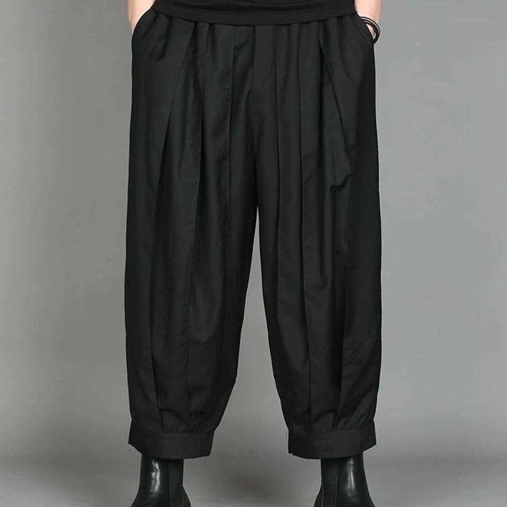 Front view of men's urban dark pleated casual pants styled with black leather boots