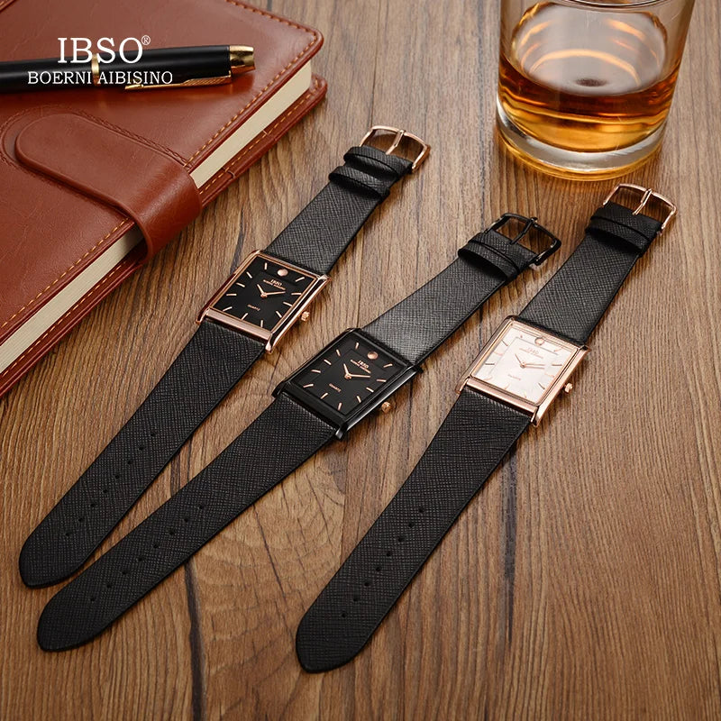Flat lay collection display of three IBSO rectangular quartz watches in different color combinations next to a glass of whiskey and a notebook