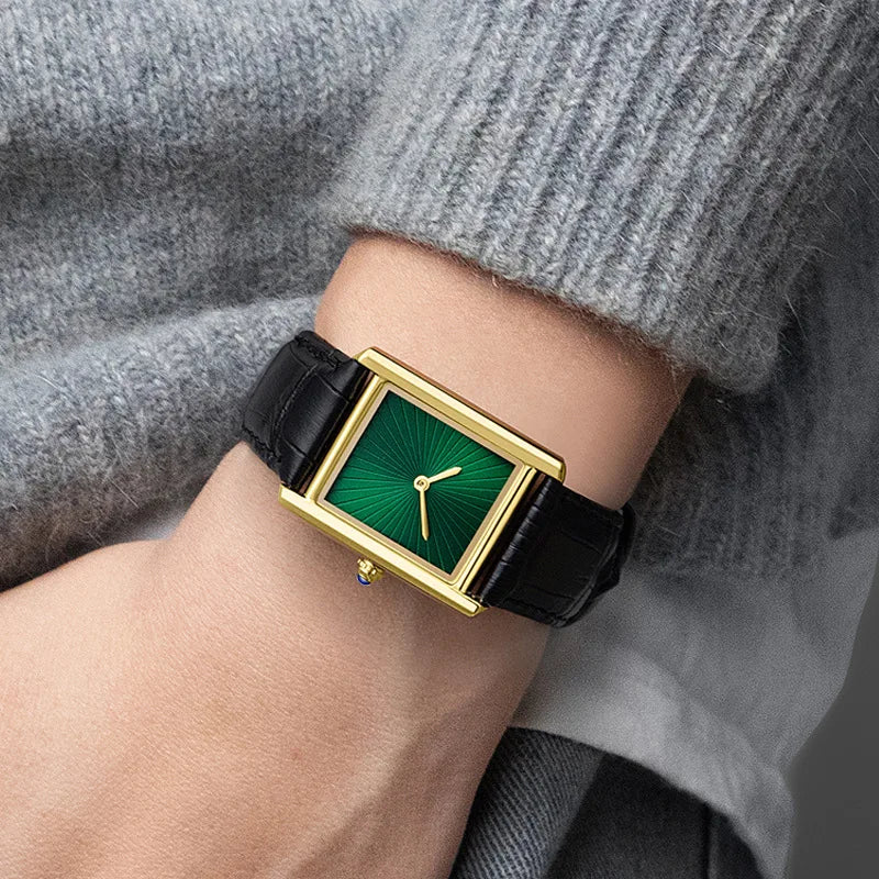 Elegant ZBJP gold wrist watch with an emerald green dial being worn, perfectly complementing a grey winter knit outfit
