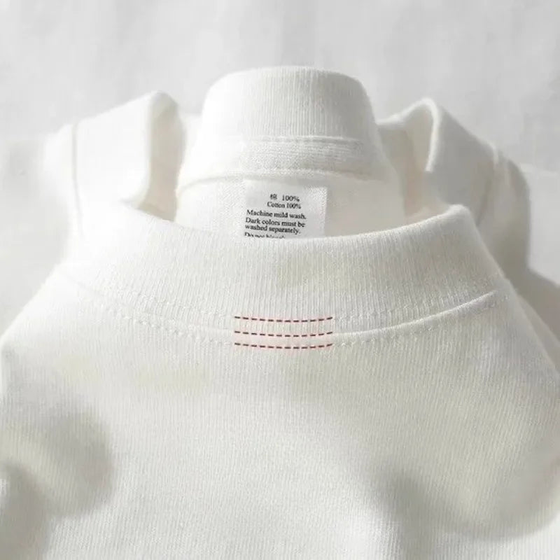 Close-up view of the back collar on a white 425g cotton t-shirt highlighting the clean red line contrast reinforcement stitching