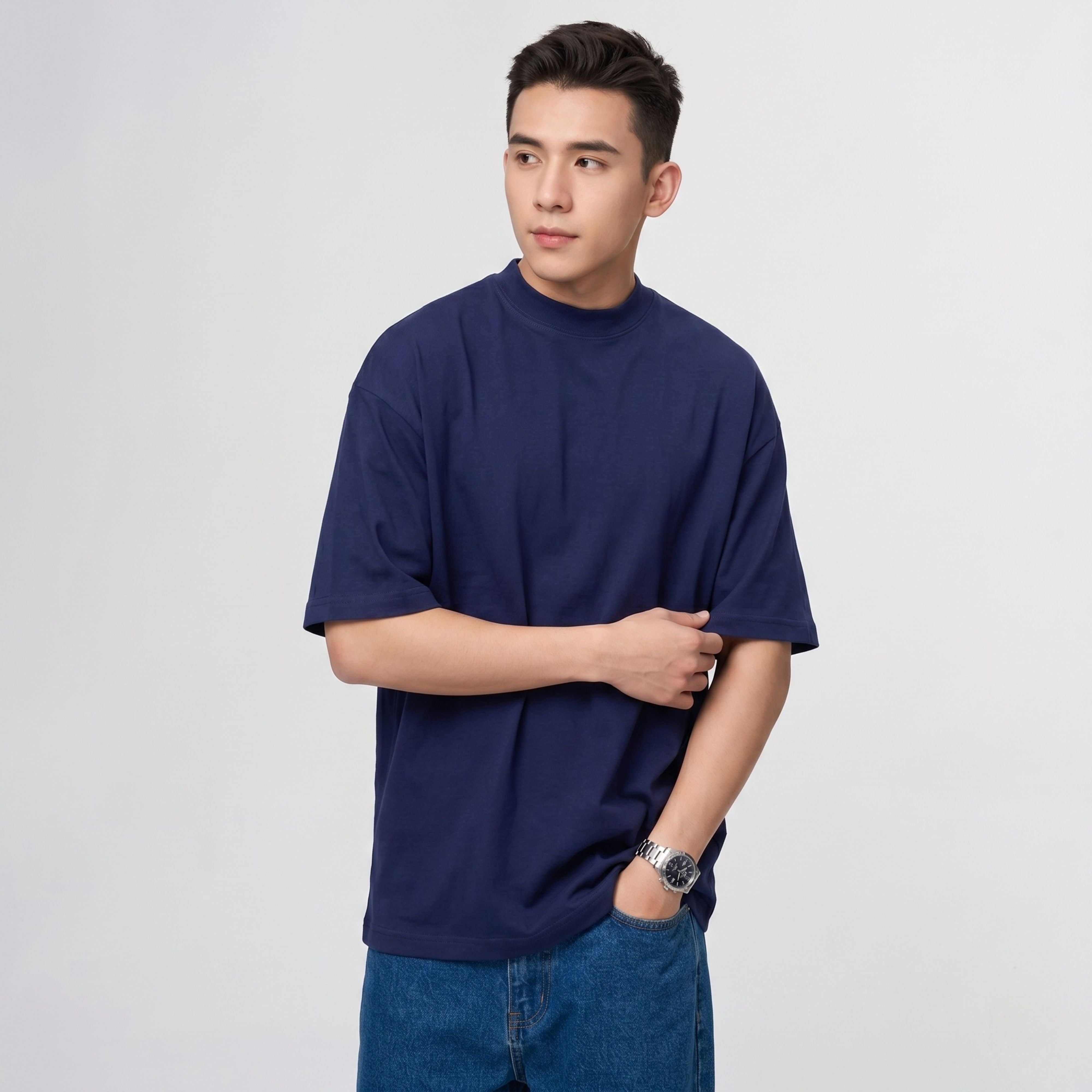 A male model posing with arms crossed to showcase the structural sleeve length and shoulder drape of the navy blue heavy cotton tee