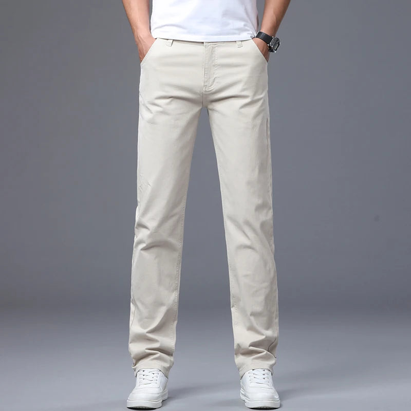 Front view of a male model modeling the off-white beige ivory mid-rise straight leg jeans, styled with white casual tennis shoes for a clean business daily look