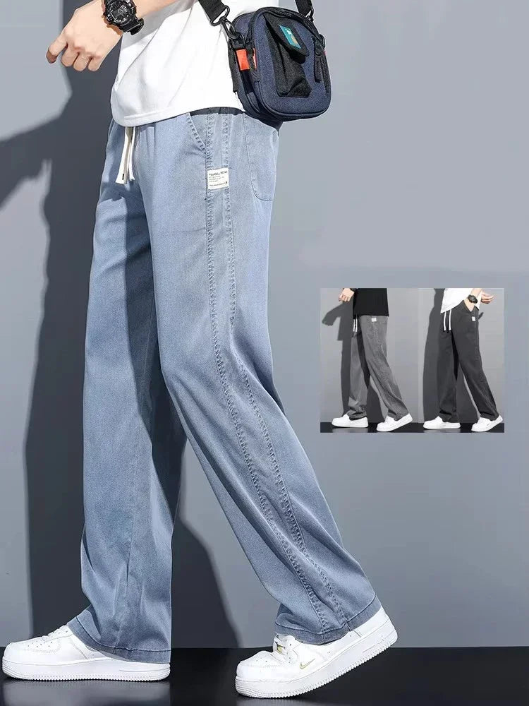 Side profile of a male model wearing light blue loose straight-leg Lyocell jeans paired with white sneakers