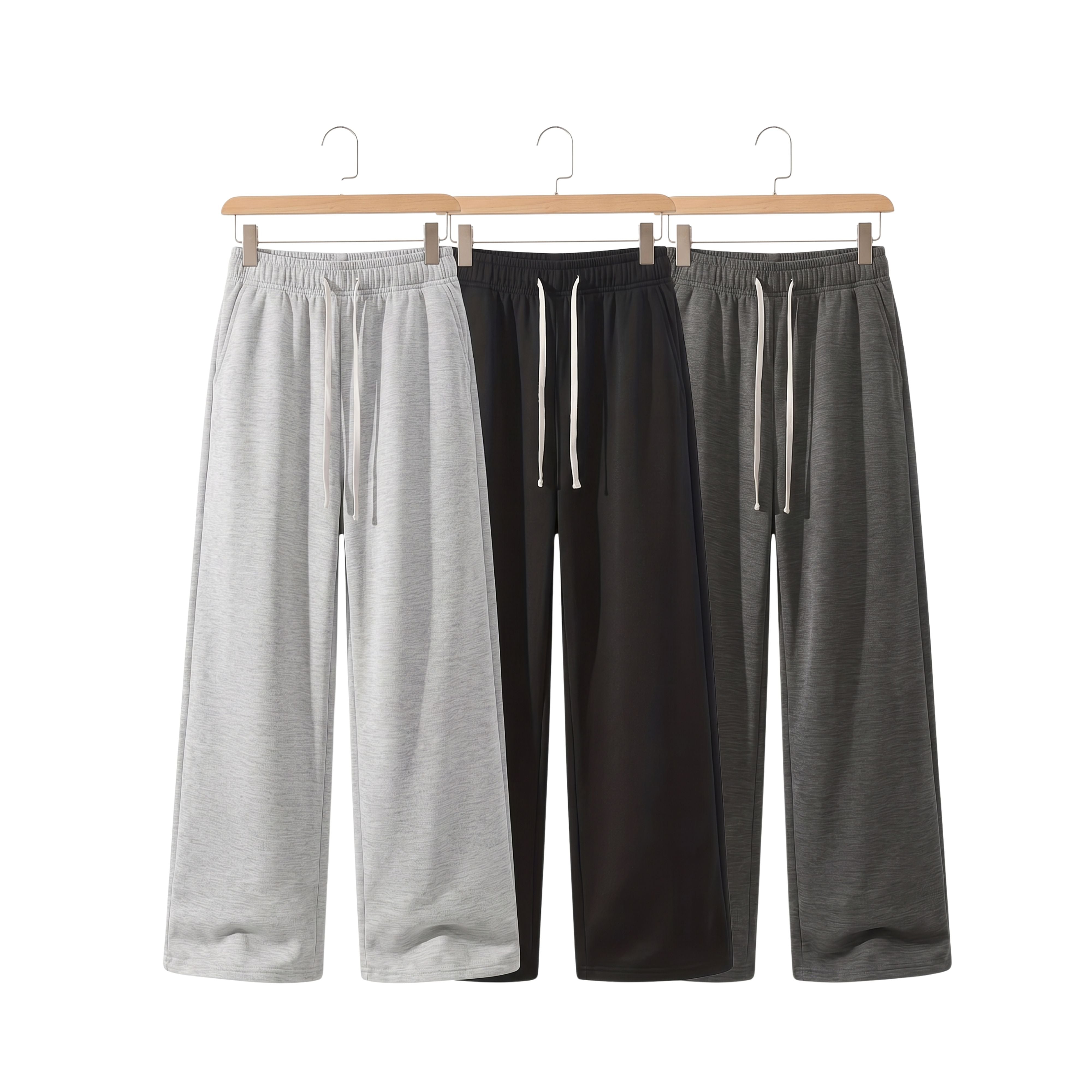 Studio product display showcasing three loose fit knitted sweatpants variants in light grey, dark grey, and classic black with white drawstrings