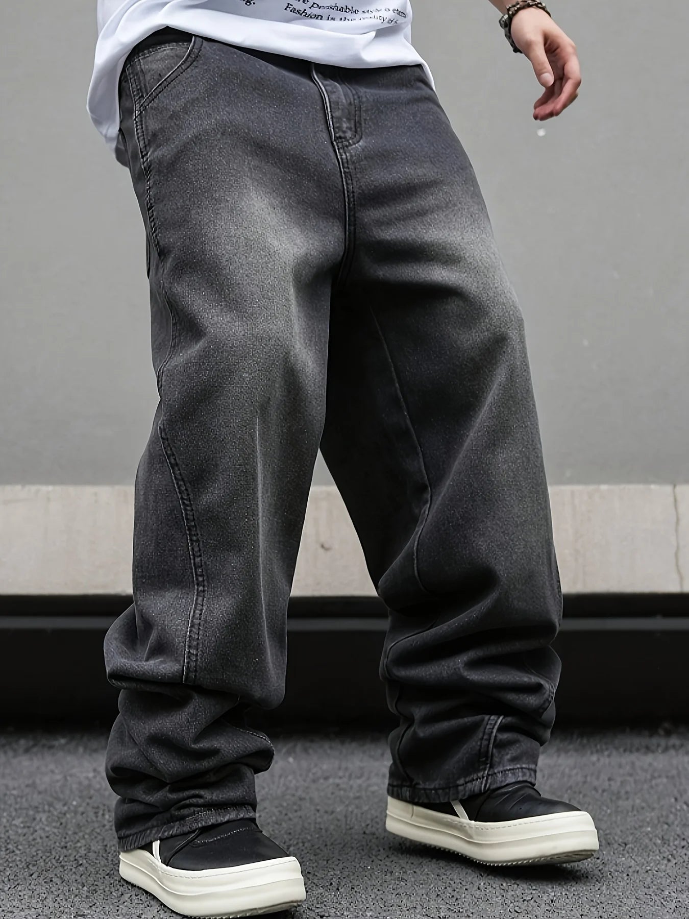 Back view of men's premium midweight rigid denim trousers showing the elegant baggy puddle profile