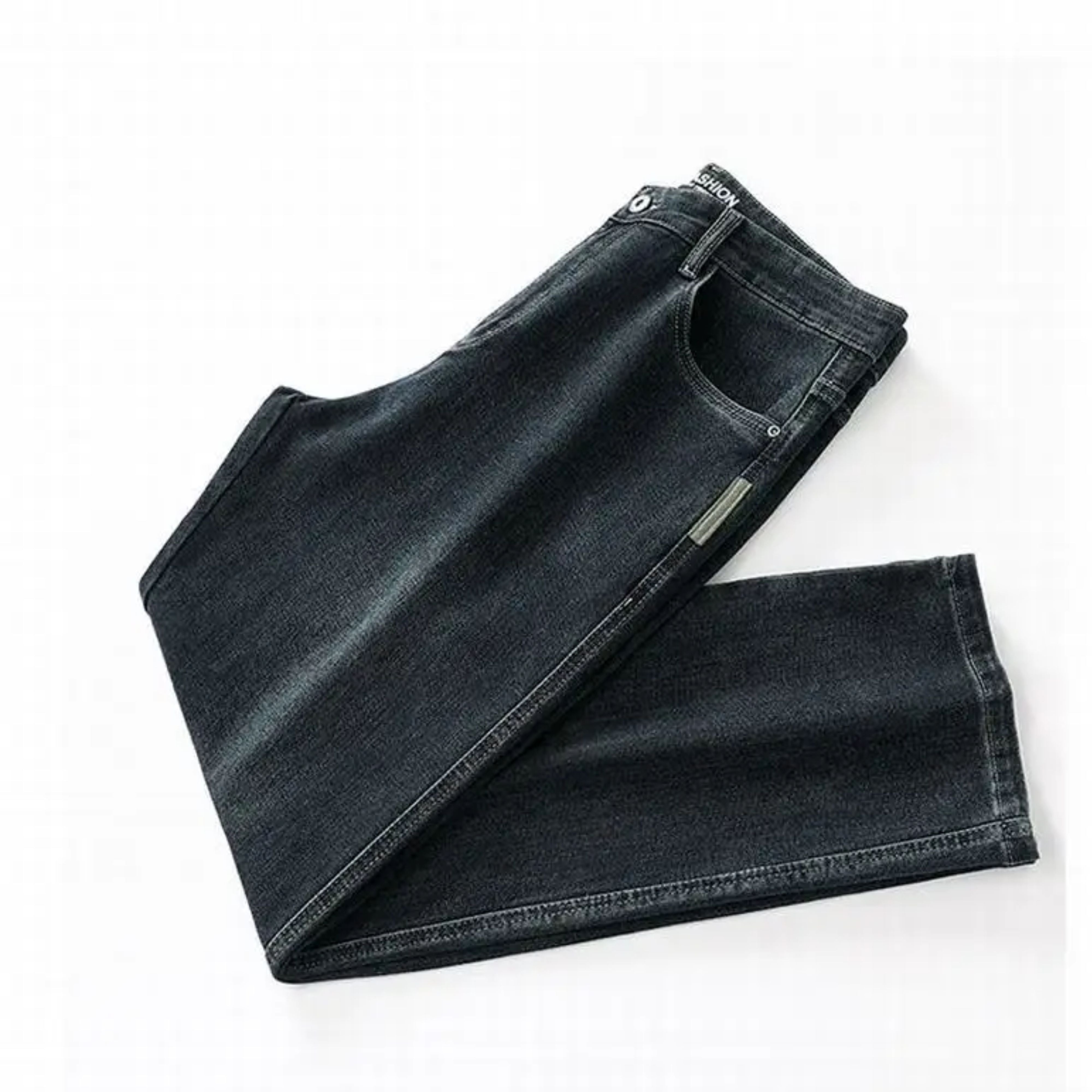 Studio flat lay presentation of the dark blue stretch jeans folded in profile, displaying the clean lines of the loose wide-leg cut