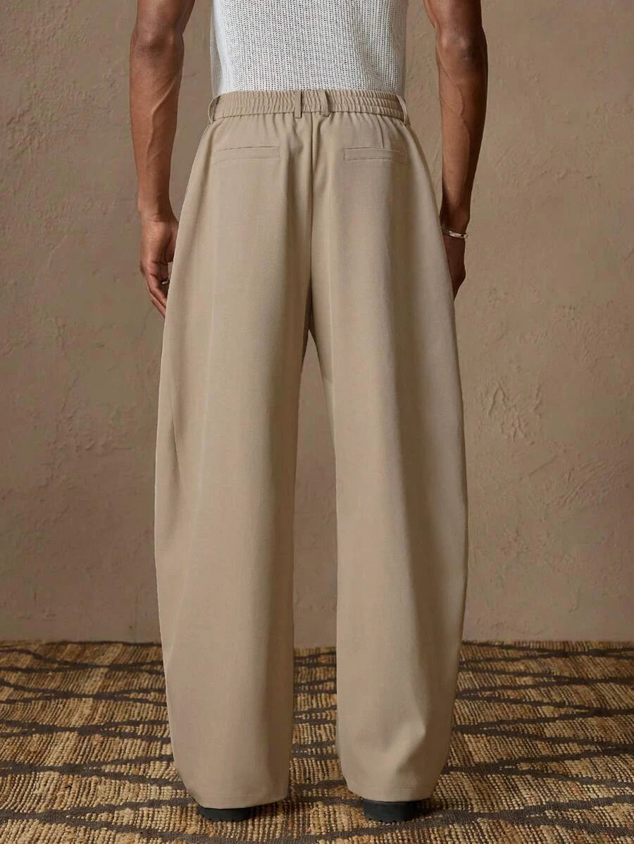 Back view of men's tailored suit pants in khaki showing the modern wide-leg drapery