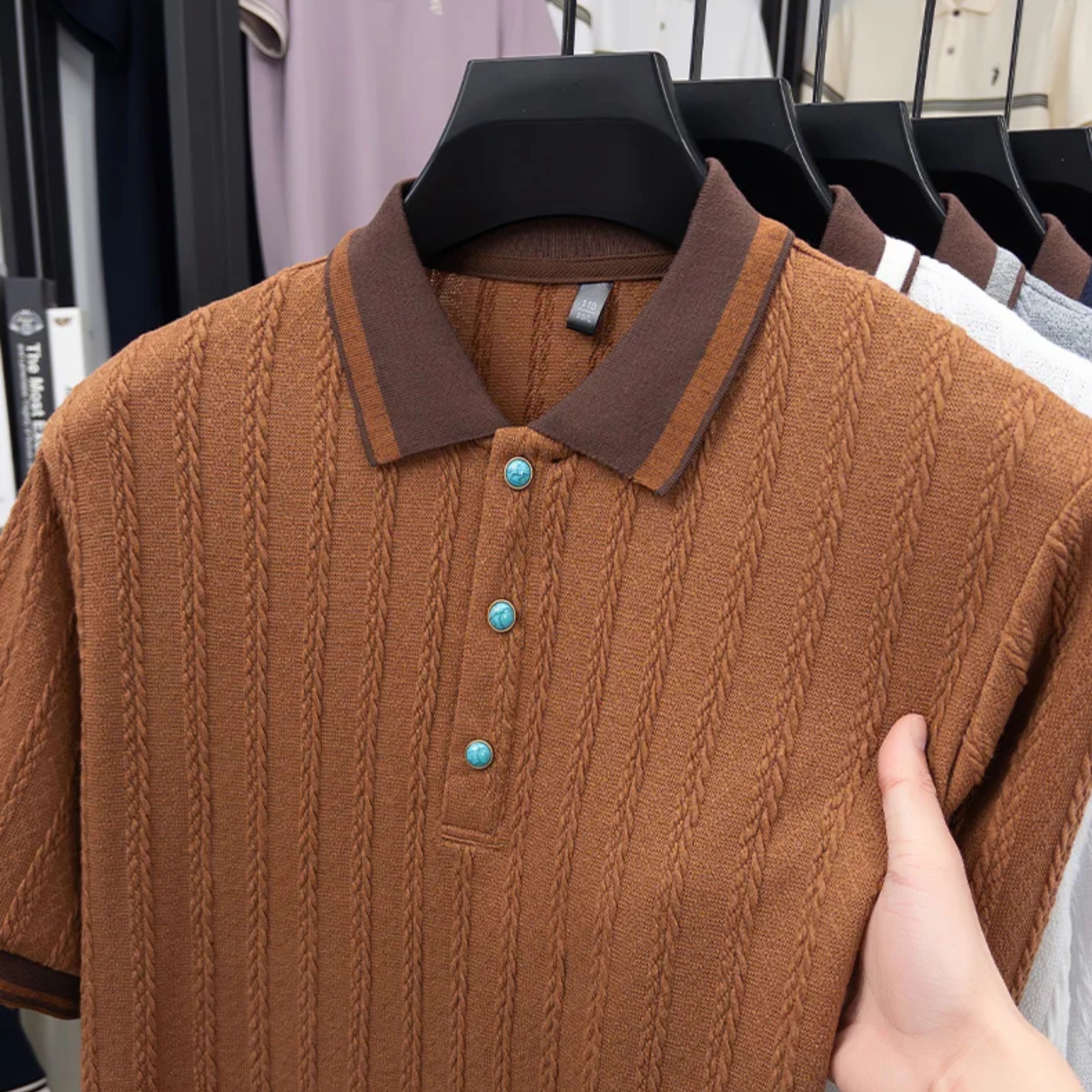 Side detail view of the structured regular fit and contrast ribbed cuff on the brown retro polo shirt