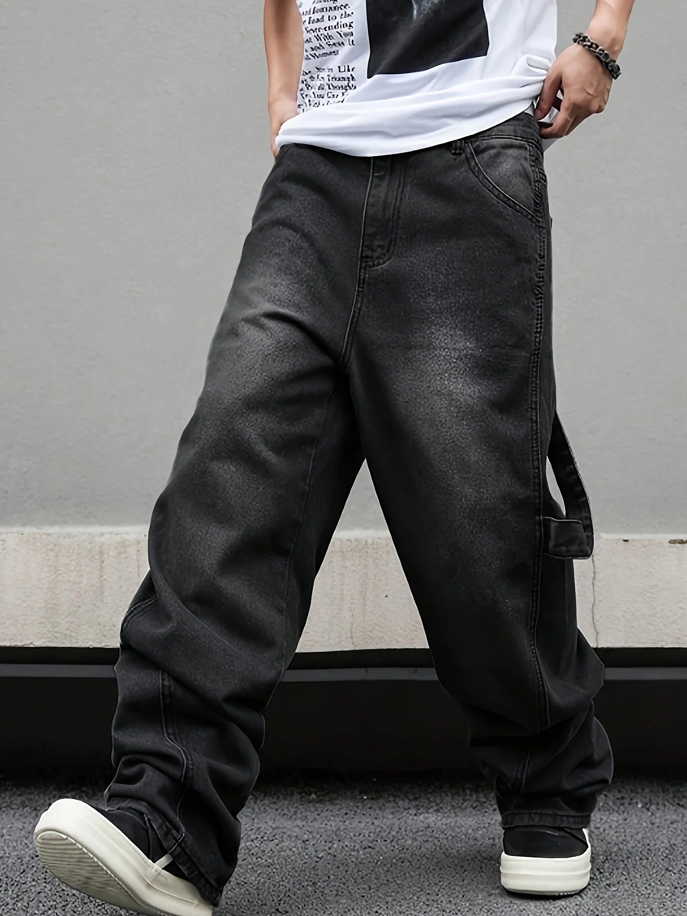 Front view of a model showcasing the relaxed hanging wide leg design of the pleated black denim pants