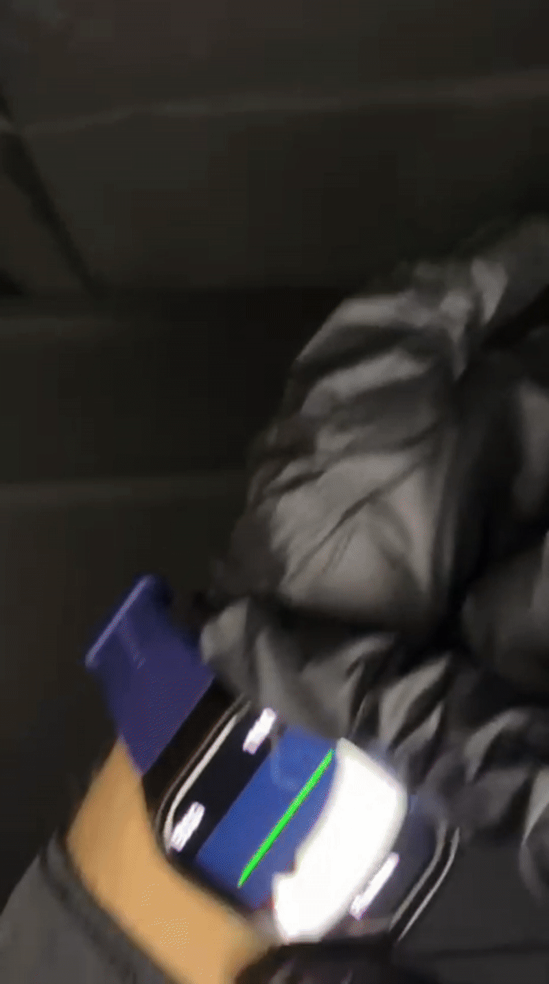 Close-up of a smartwatch screen displaying live ECG, HRV, and PPG health metrics with a green pulse wave and deep blue silicone strap