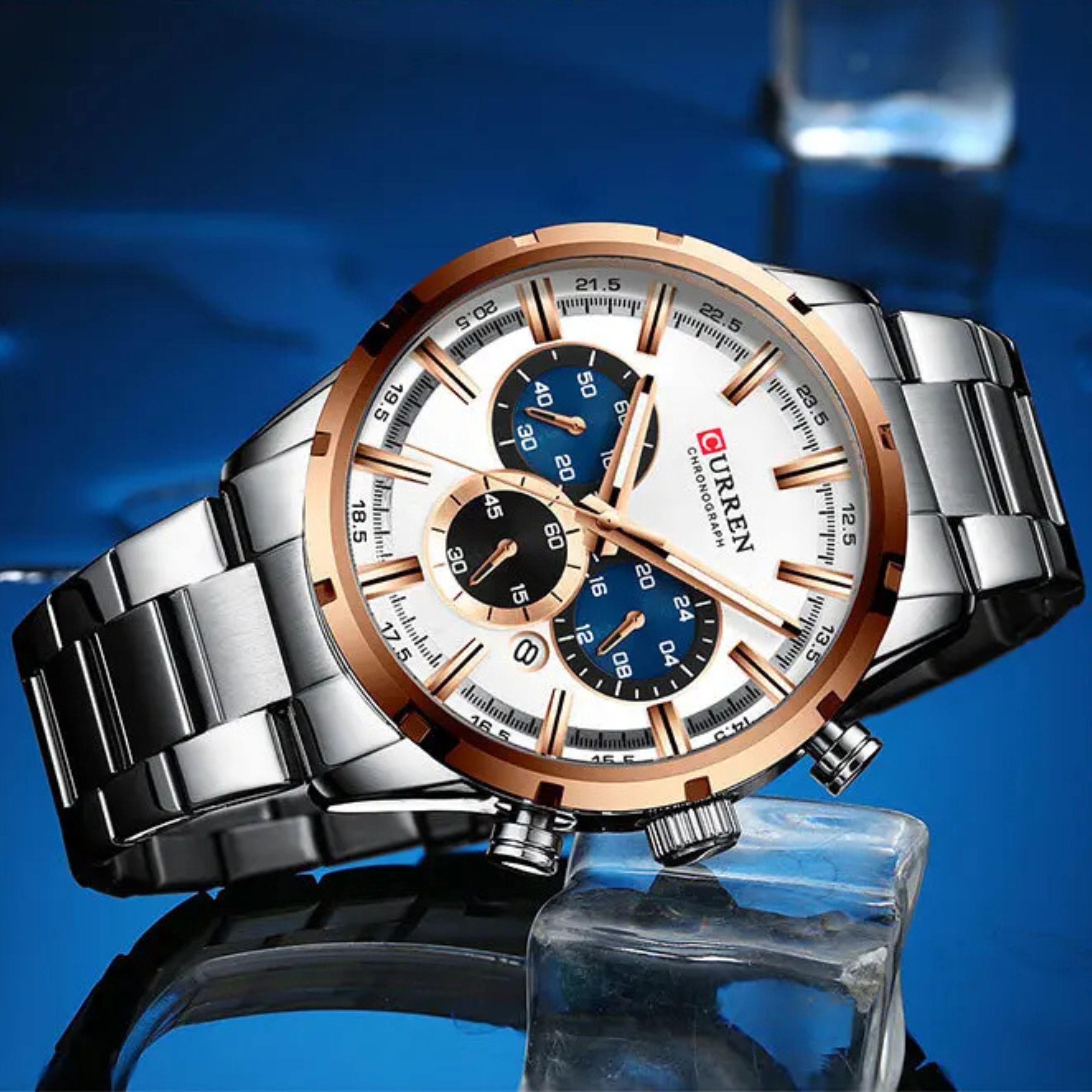 Luxury silver Curren watch with black dial sitting on wet ice cubes with creative blue lighting