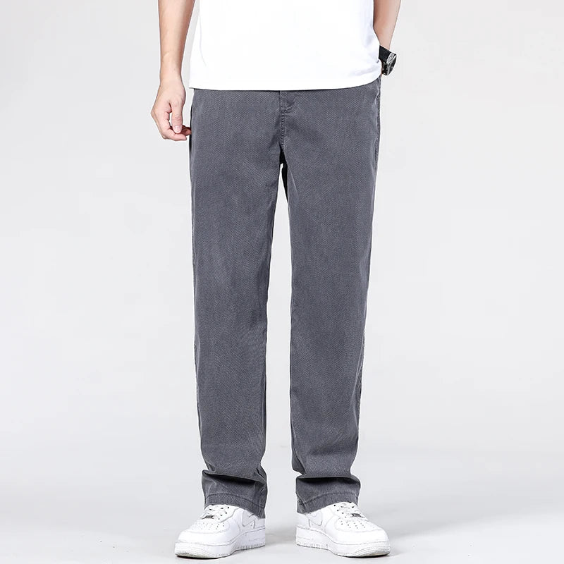 Front view of a model showcasing the fluid drape and flat-front waist architecture of the mid-grey summer lightweight pants with white tennis shoes