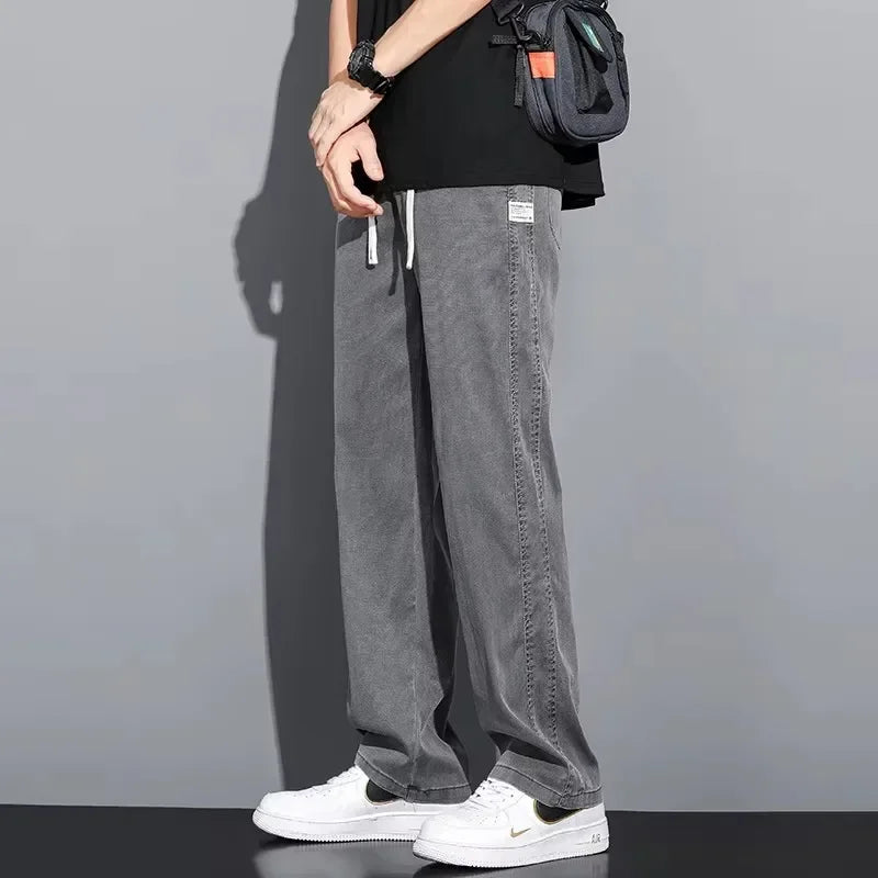 Side profile shot of a man wearing comfortable, midweight gray loose casual pants with a minimalist streetwear design