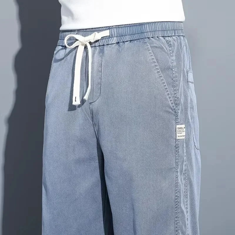 Close-up detail of the flexible elastic waist, thick white cotton drawstring cord, and side pocket stitching on light blue Lyocell pants