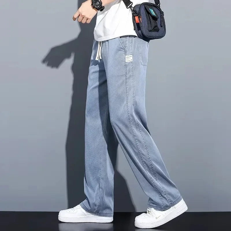 Model in motion showcasing the fluid, breathable drape of light blue straight-leg summer pants for men