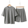 Men's Seoul Street two-piece coordinated set in grey jacquard plaid, showcasing an oversized short-sleeve T-shirt and matching drawstring shorts on hangers