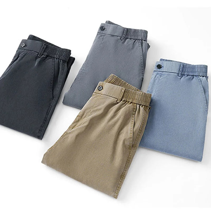 A studio flat lay presentation showing four neatly folded pairs of the ultrathin summer Lyocell casual trousers in black, grey, khaki, and light blue