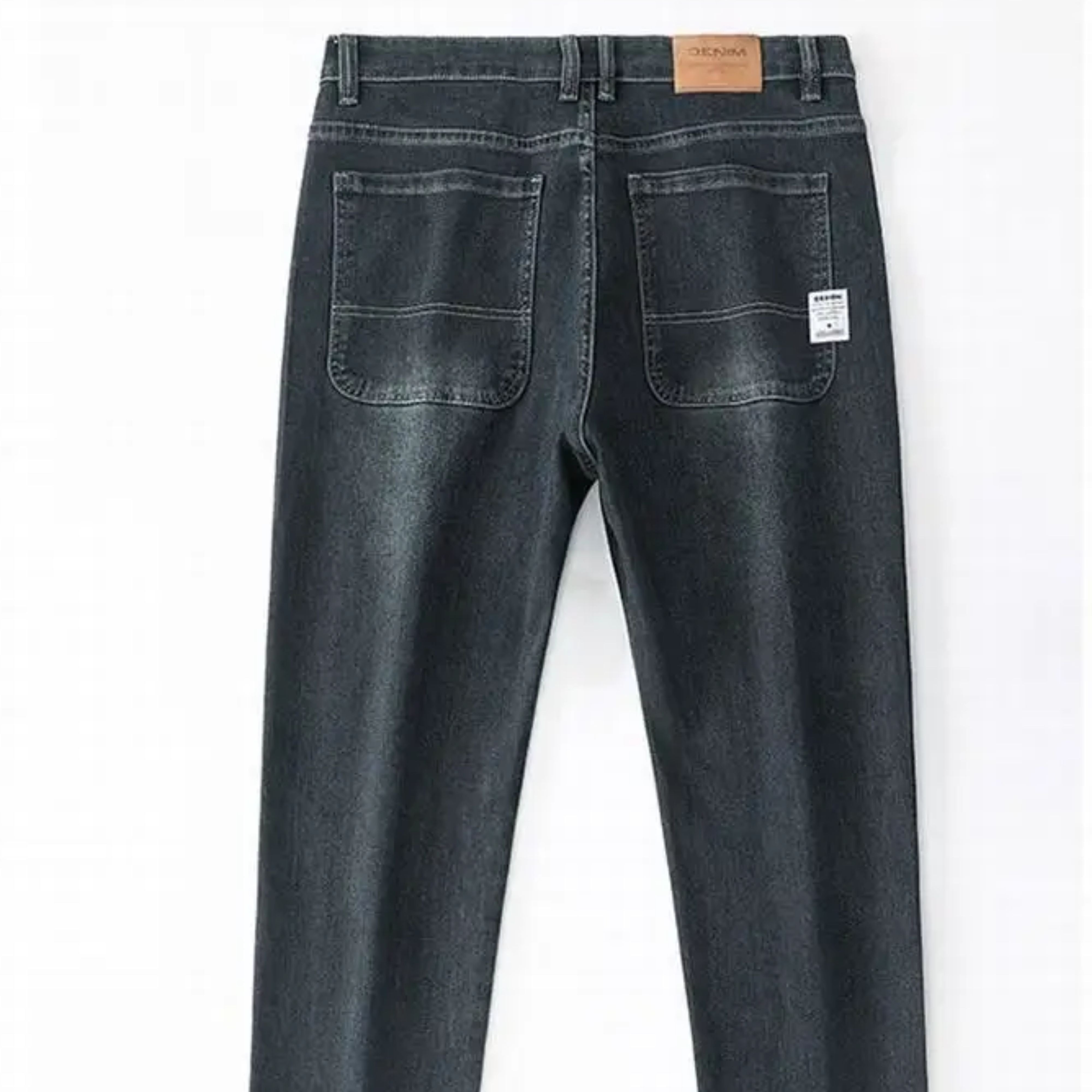Studio view of the upper back section of the denim trousers, highlighting the mid-rise waist layout, belt loops, and traditional leather patch