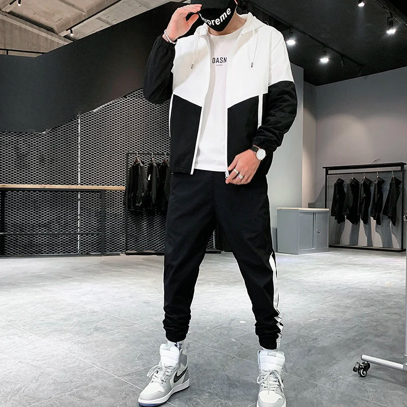 Front view of a male model showcasing the relaxed hip-hop style silhouette of the black and white single-glide zipper sportswear outfit