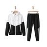 Men's Metropolitan Vibe two-piece sportswear tracksuit featuring a white and black geometric patchwork hooded zip jacket and matching joggers on hangers