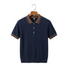 Front studio view of a men's short-sleeve jacquard knitted polo shirt in navy blue with a brown contrast collar