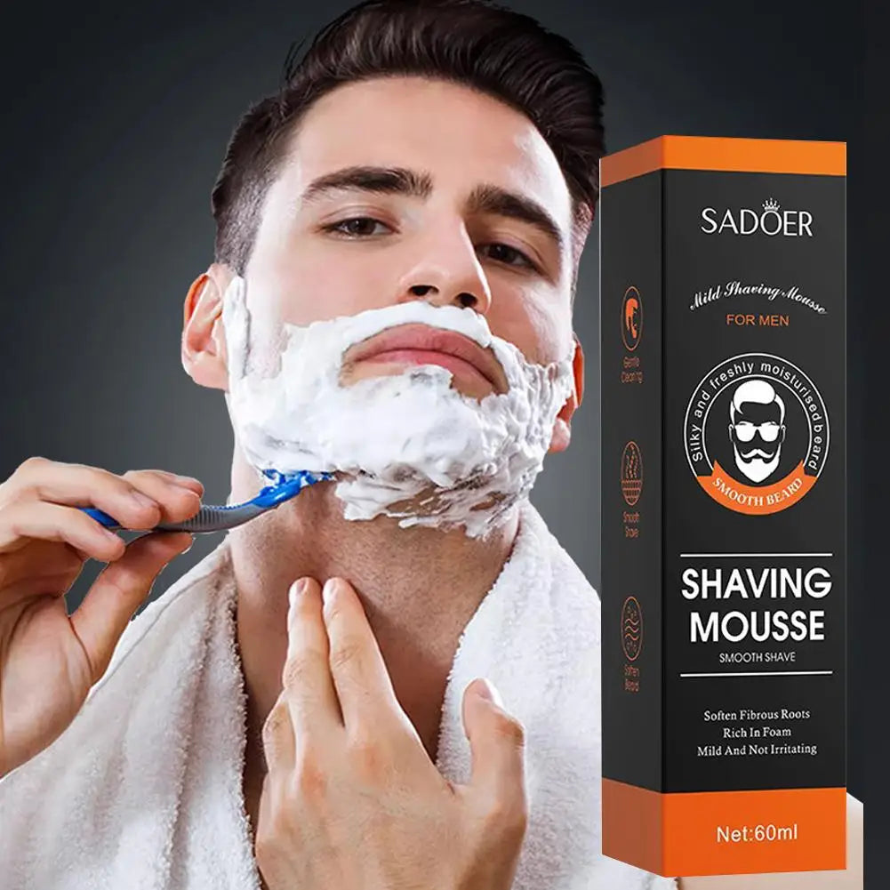 Young man shaving his neck with a razor and thick white Sadoer mousse lather next to the product packaging box