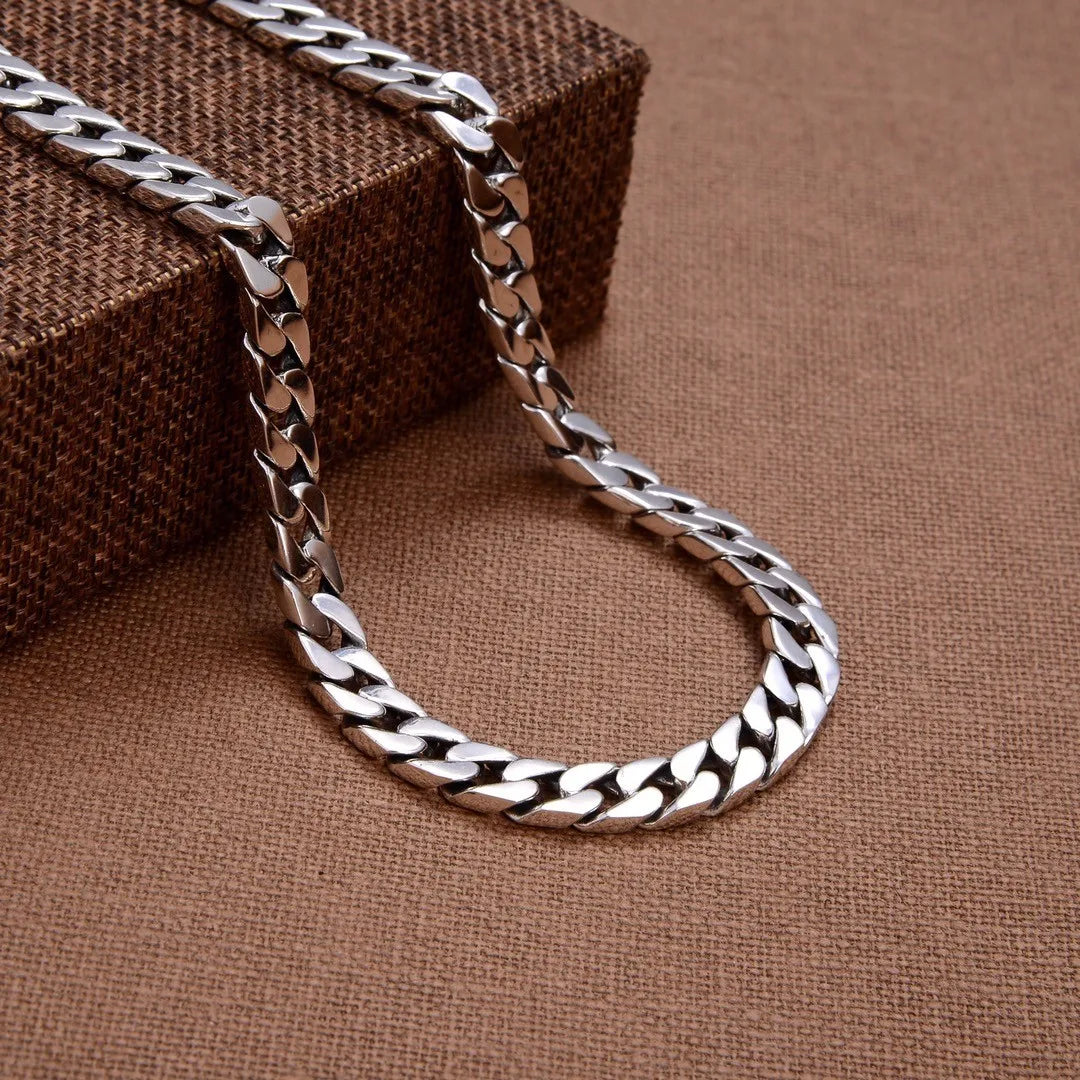 Polished silver Miami Cuban link necklace draped elegantly over a brown display box.