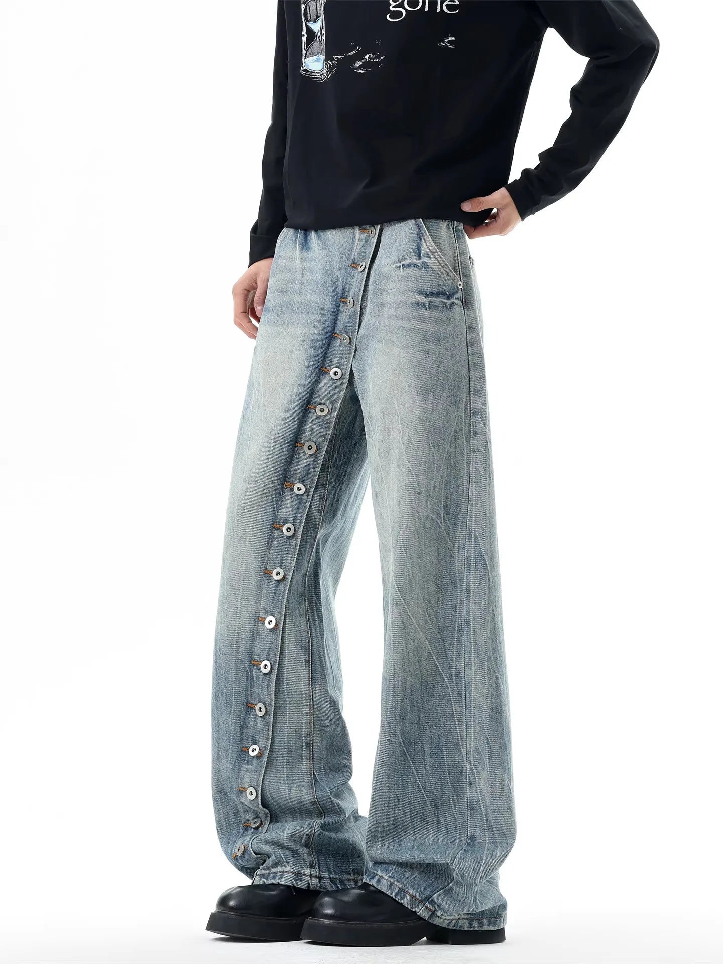 Side profile of a model wearing light blue cross-over button fly baggy trousers for urban streetwear look