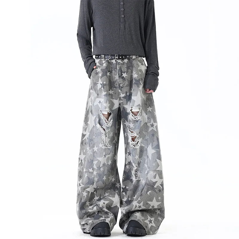 Model wearing gray oversized high-street trousers covered in a faded all-over distressed star pattern
