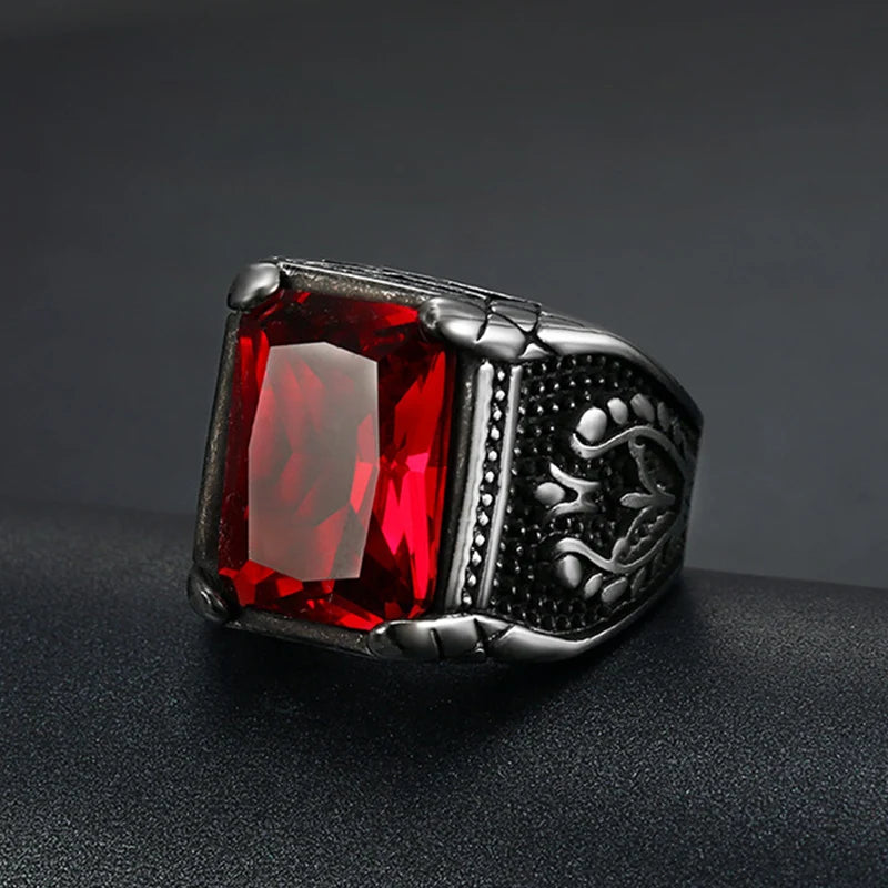 Vintage silver signet ring featuring a vibrant red rectangular gemstone on a dark surface.