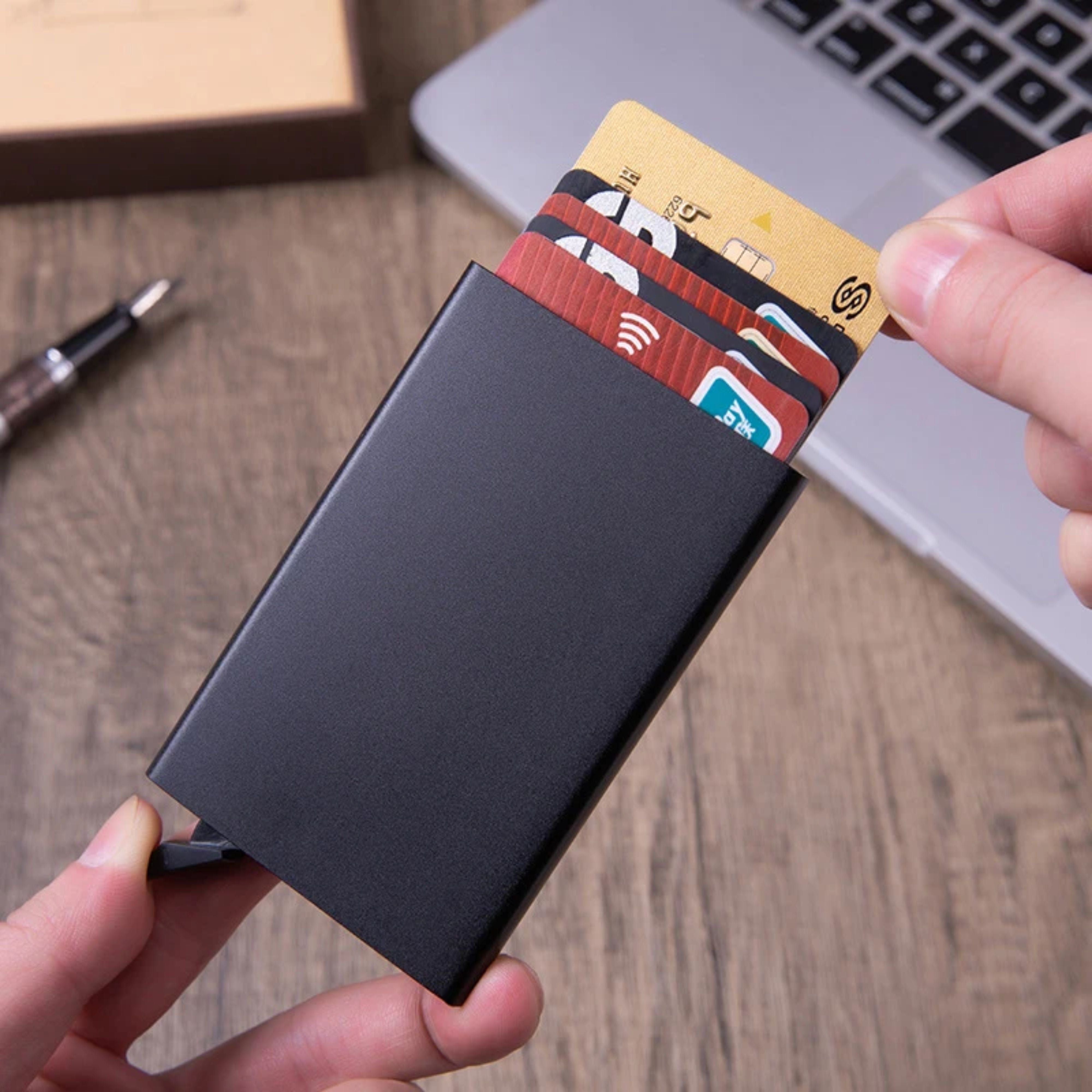 Close-up demonstration showing a user easily pulling a single credit card out from the fanned-out deck of the metallic wallet